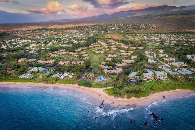 aerial view at dusk with a view of the beach and a water view