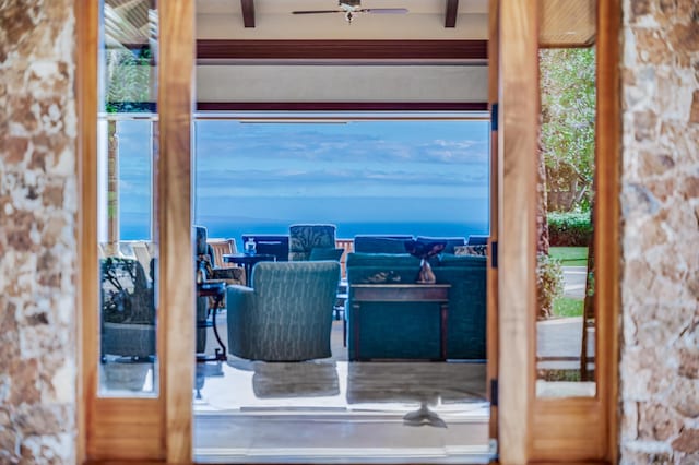 interior space with ceiling fan, beam ceiling, and a water view