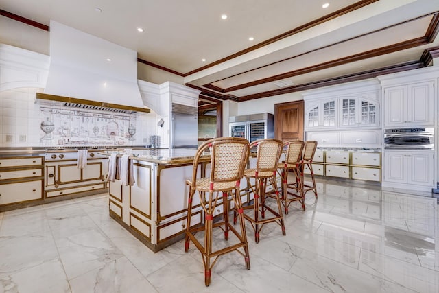 kitchen with a center island, ornamental molding, tasteful backsplash, custom range hood, and stainless steel appliances