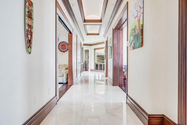 corridor with a raised ceiling and crown molding