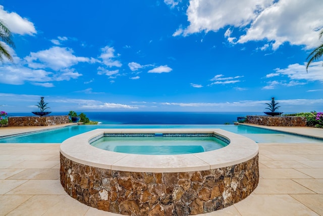 view of pool featuring an in ground hot tub and a water view