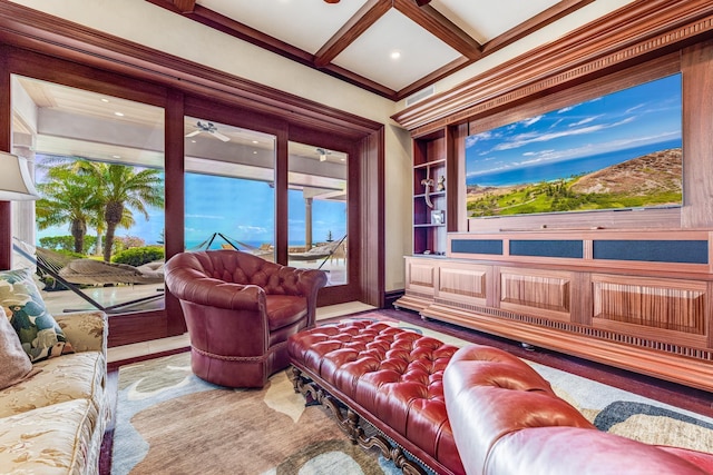 cinema room with built in shelves, ceiling fan, coffered ceiling, beamed ceiling, and crown molding