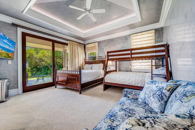 carpeted bedroom with a tray ceiling, access to exterior, ceiling fan, and multiple windows