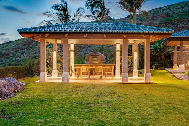 exterior space featuring a gazebo, a patio area, a mountain view, and a yard