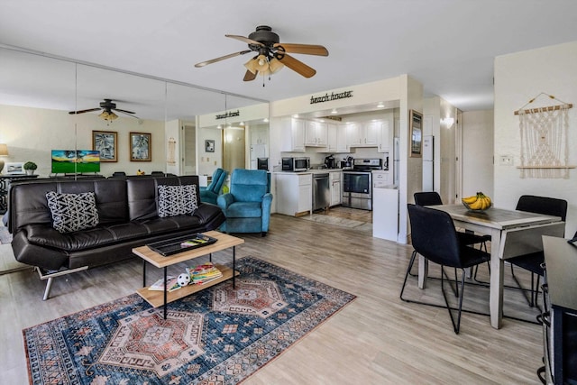 living area with light wood finished floors and a ceiling fan