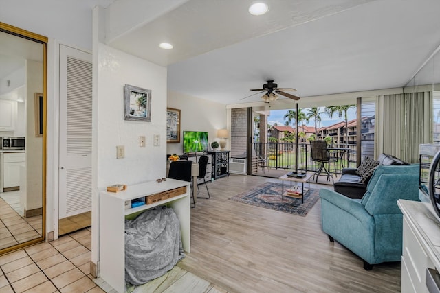 living room featuring light wood-style floors, a sunroom, a ceiling fan, and recessed lighting