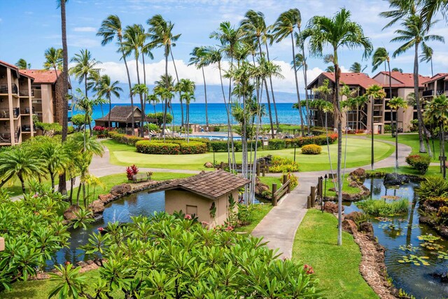 surrounding community featuring a water view and a lawn