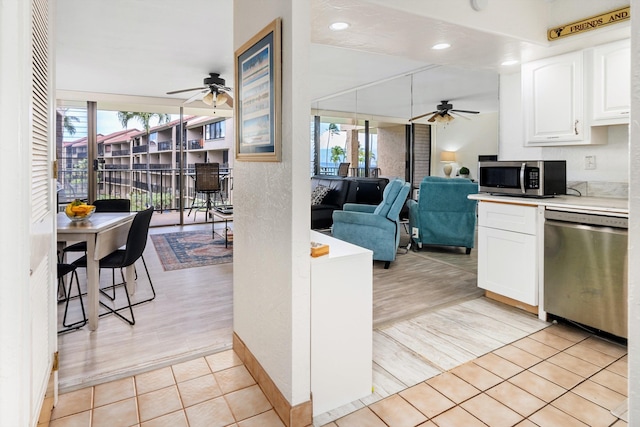 kitchen featuring light countertops, appliances with stainless steel finishes, a wealth of natural light, and white cabinets