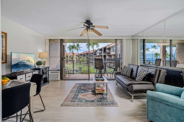 living room featuring a ceiling fan, expansive windows, and wood finished floors