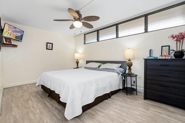 bedroom featuring a ceiling fan, baseboards, and wood finished floors