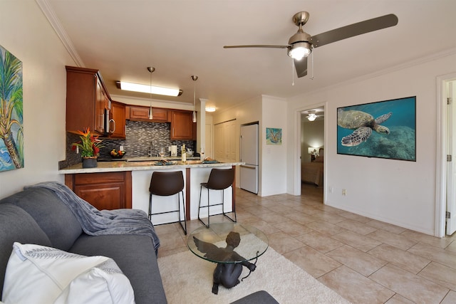 tiled living room featuring crown molding, ceiling fan, and sink