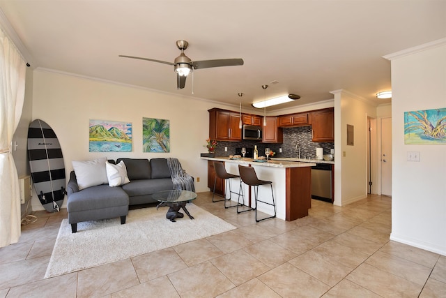 tiled living room with ceiling fan, sink, and ornamental molding