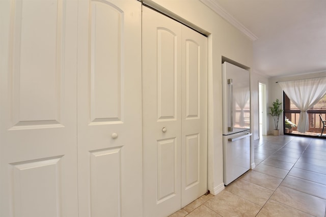 hallway with crown molding and light tile patterned floors