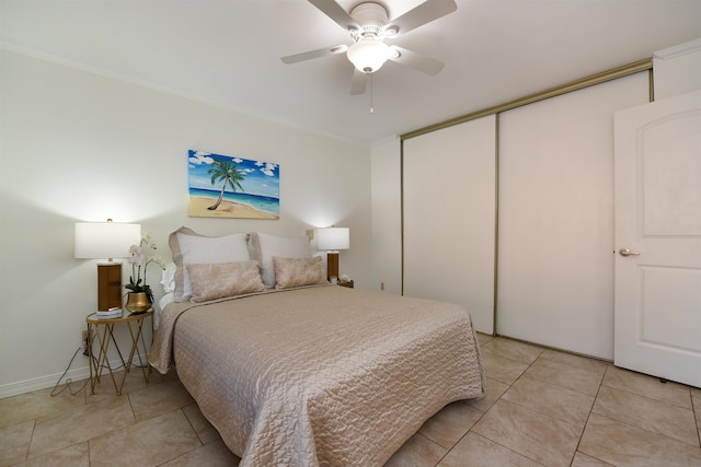 bedroom with light tile patterned floors, crown molding, ceiling fan, and a closet