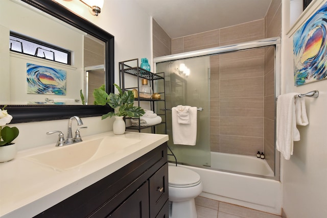 full bathroom featuring vanity, toilet, tile patterned flooring, and bath / shower combo with glass door