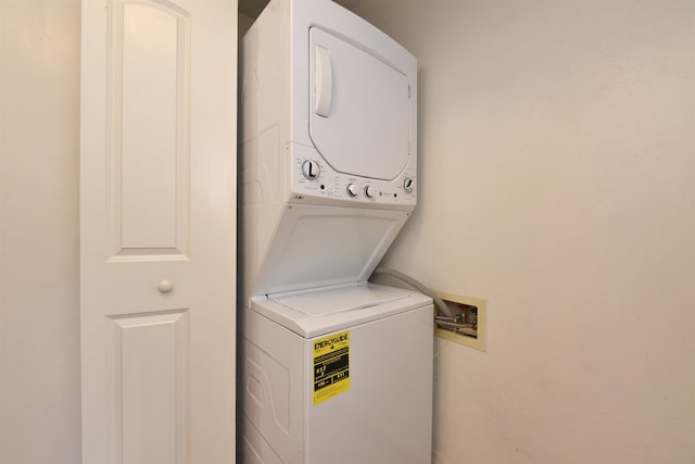 clothes washing area featuring stacked washer / drying machine