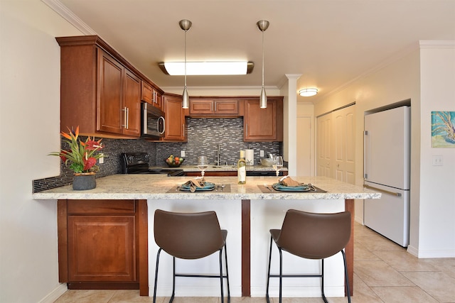 kitchen featuring pendant lighting, kitchen peninsula, decorative backsplash, white refrigerator, and black range with electric stovetop