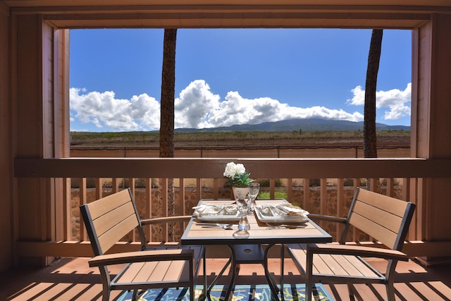 sunroom / solarium with a mountain view, plenty of natural light, and a rural view