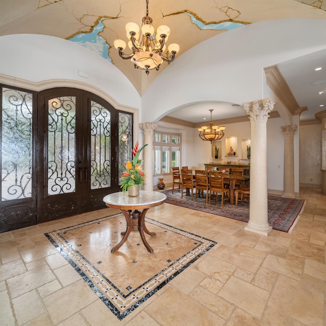 foyer with a notable chandelier, french doors, crown molding, and decorative columns