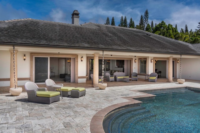 back of house with an outdoor living space and a patio area