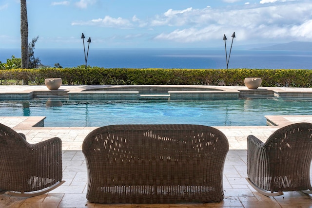 view of pool featuring a water view, an in ground hot tub, and a patio area