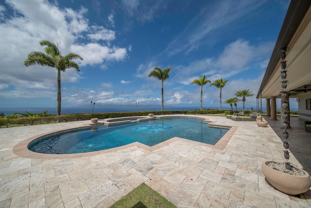 view of pool with ceiling fan, a water view, and a patio area