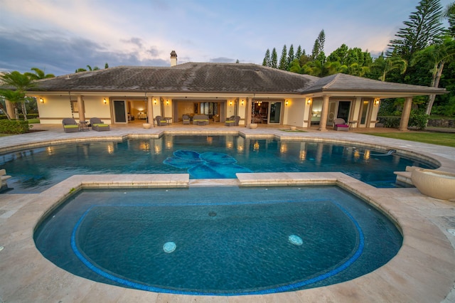 pool at dusk with a patio