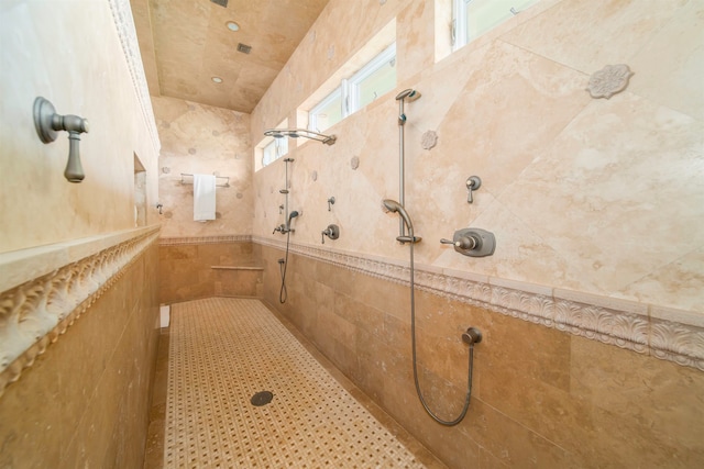 bathroom featuring tiled shower and tile walls