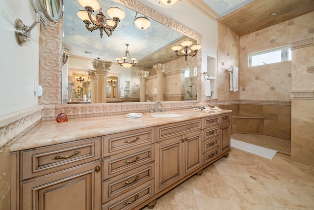 bathroom featuring vanity, tile walls, decorative columns, and tiled shower