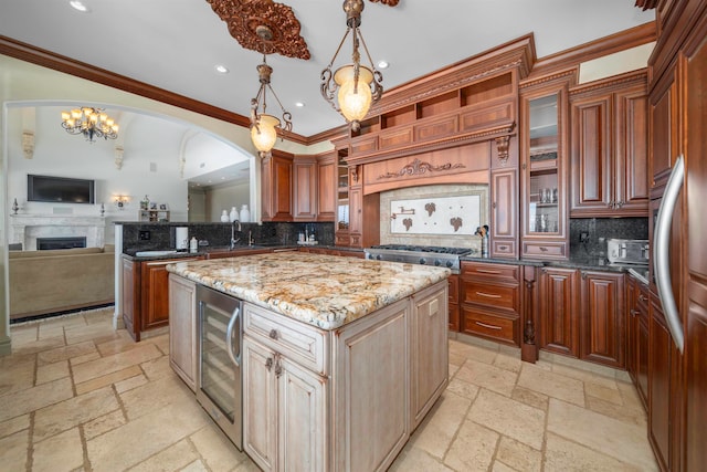 kitchen featuring light stone counters, wine cooler, ornamental molding, a center island, and decorative backsplash