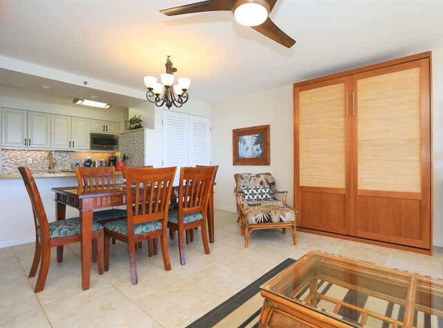 dining room featuring sink, ceiling fan with notable chandelier, and light tile patterned flooring