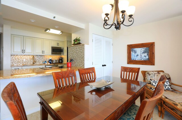 dining room with sink and a chandelier