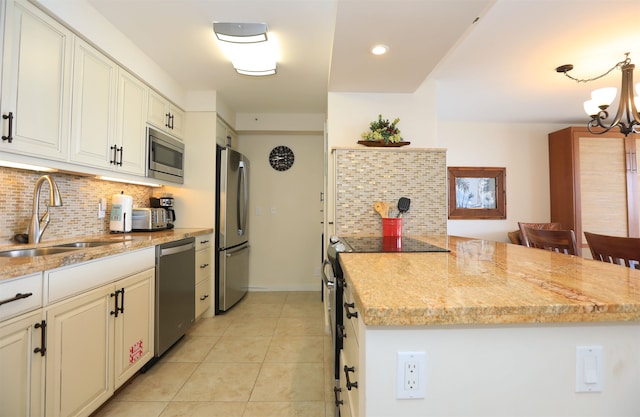 kitchen featuring an inviting chandelier, stainless steel appliances, sink, light stone counters, and light tile patterned flooring