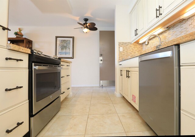 kitchen with backsplash, stainless steel appliances, light tile patterned flooring, ceiling fan, and white cabinets