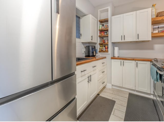 1063 Lower Main St Unit 315, Wailuku, HI 96793 - kitchen with open shelves, stainless steel appliances, wood counters, and white cabinets