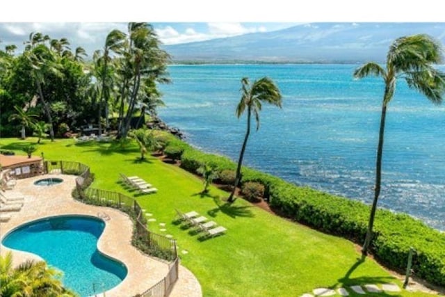 view of swimming pool featuring a water view and a lawn