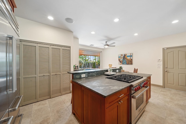 70 Pukolu Way, Kihei, HI 96753 - kitchen with premium appliances, a kitchen island, ceiling fan, recessed lighting, and dark stone countertops