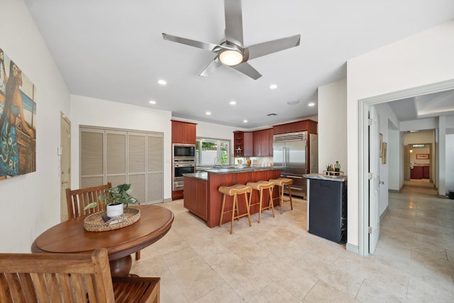 70 Pukolu Way, Kihei, HI 96753 - kitchen featuring built in appliances, a ceiling fan, a sink, a kitchen bar, and a center island