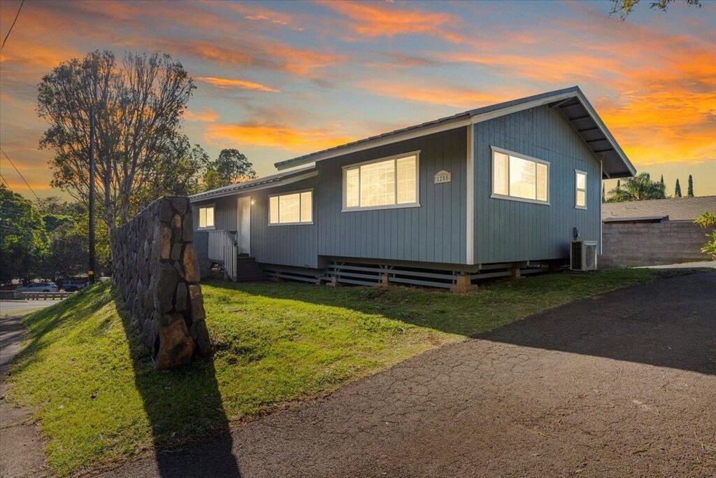 property exterior at dusk with a yard