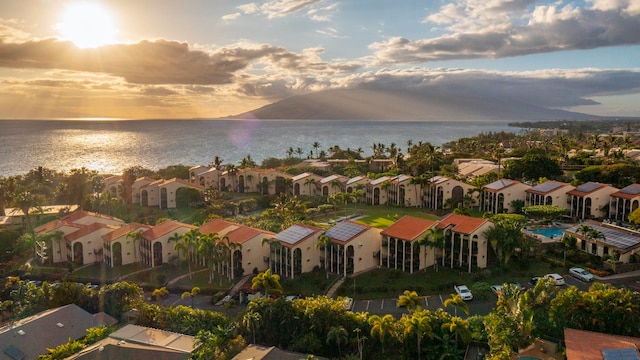 aerial view at dusk featuring a water view