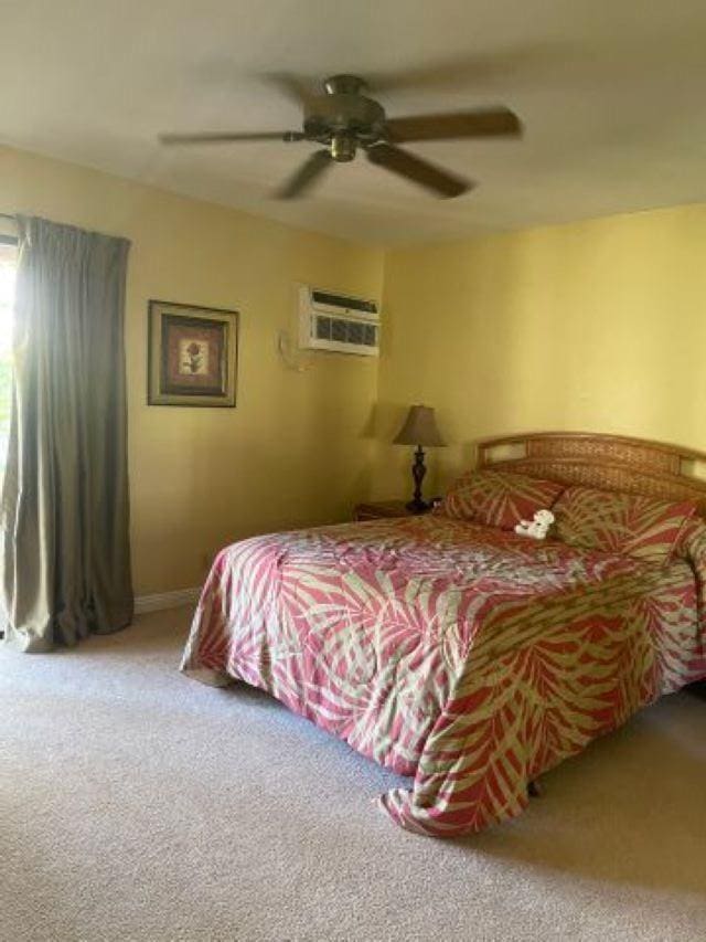 carpeted bedroom featuring ceiling fan and a wall unit AC