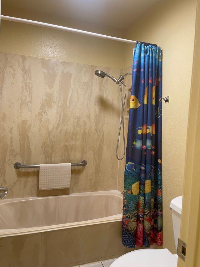 bathroom featuring shower / bath combo and toilet