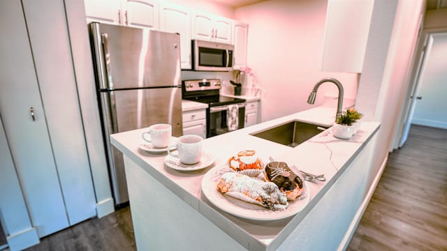 140 Uwapo Rd Unit 2-202, Kihei, HI 96753 - kitchen featuring appliances with stainless steel finishes, white cabinets, dark wood-style floors, and a peninsula