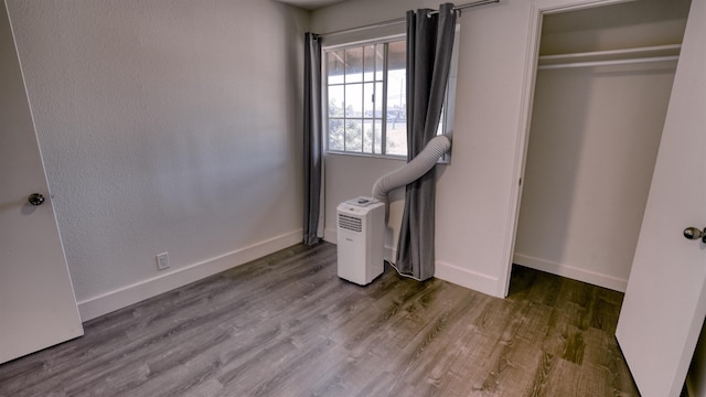 140 Uwapo Rd Unit 2-202, Kihei, HI 96753 - unfurnished bedroom with wood finished floors and a closet