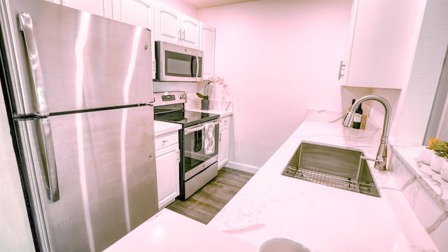 140 Uwapo Rd Unit 2-202, Kihei, HI 96753 - kitchen featuring appliances with stainless steel finishes, white cabinets, light wood-type flooring, and light stone counters