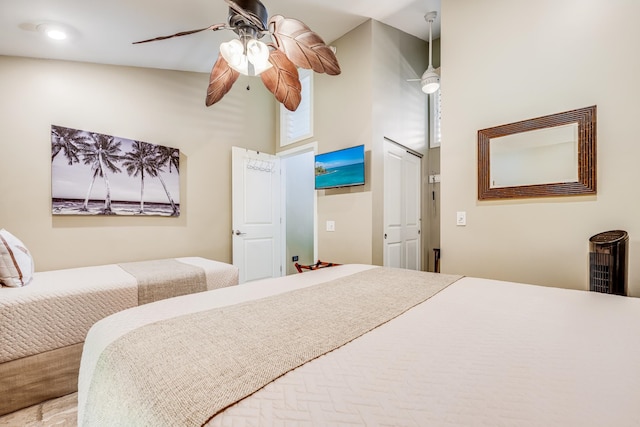 bedroom with ceiling fan and a high ceiling