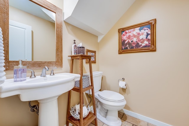 bathroom with lofted ceiling, toilet, and tile floors