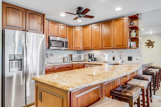 kitchen featuring appliances with stainless steel finishes, a kitchen breakfast bar, sink, and backsplash