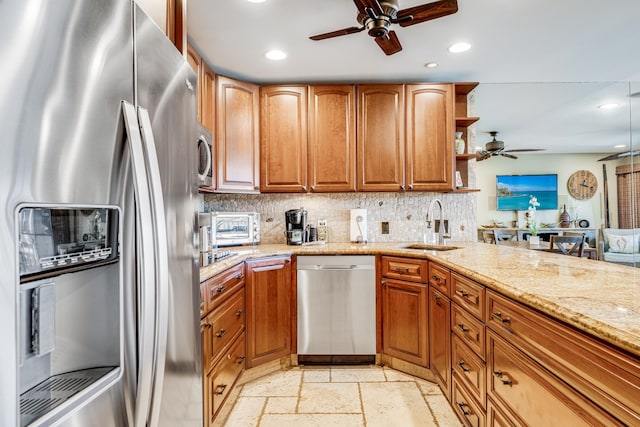 kitchen featuring appliances with stainless steel finishes, tasteful backsplash, ceiling fan, and light stone countertops