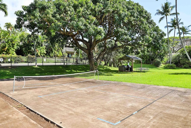 view of home's community featuring a lawn, fence, and a tennis court